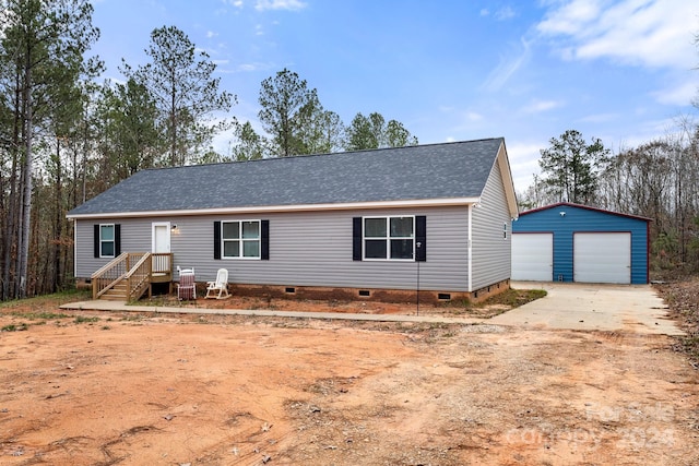 view of front of home featuring a garage and an outbuilding