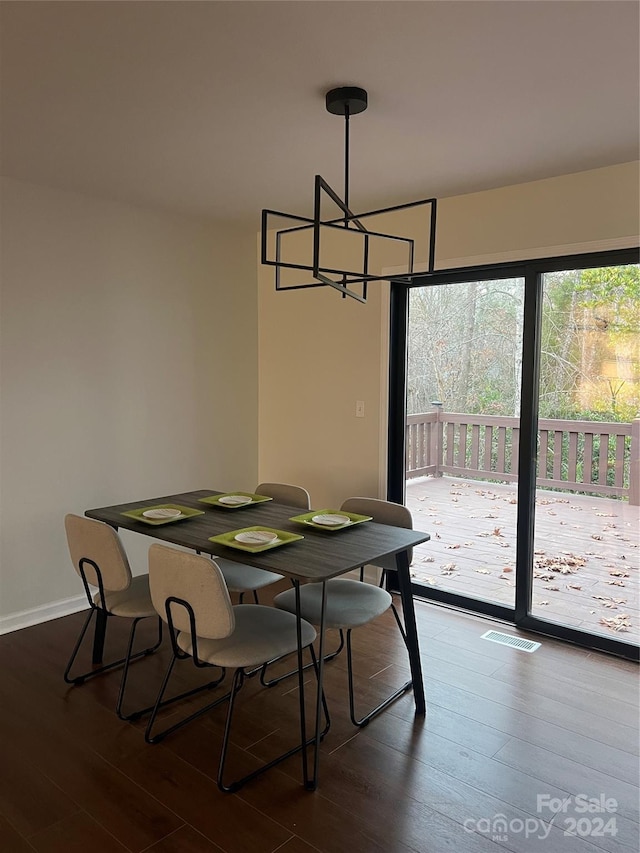 dining space with dark hardwood / wood-style floors and an inviting chandelier