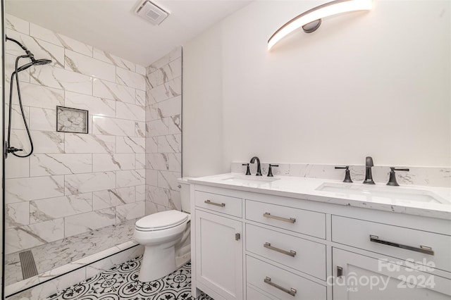 bathroom featuring tiled shower, tile patterned floors, vanity, and toilet