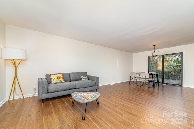 living room featuring a chandelier and wood-type flooring