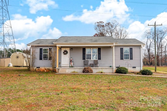 ranch-style home featuring a front yard, a porch, and a shed