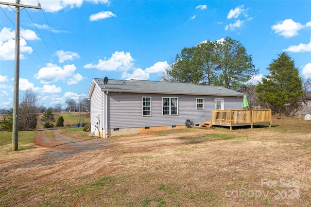 rear view of property with a lawn and a wooden deck