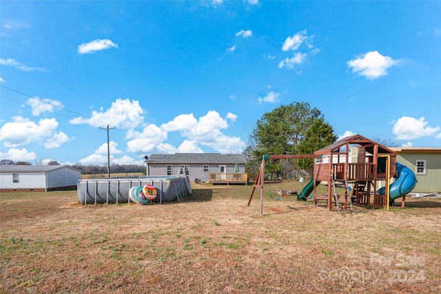 view of yard with a playground and a swimming pool