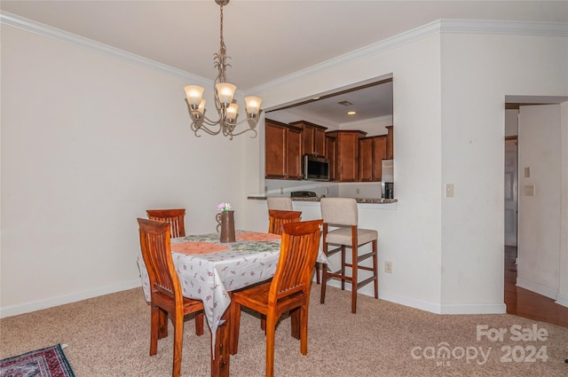 carpeted dining room with ornamental molding and an inviting chandelier