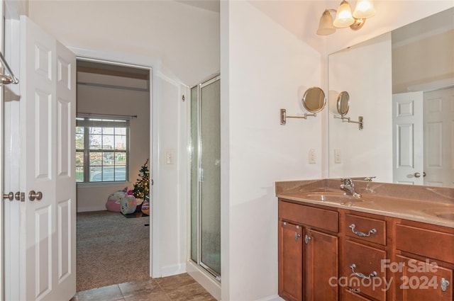 bathroom featuring tile patterned flooring, vanity, and an enclosed shower