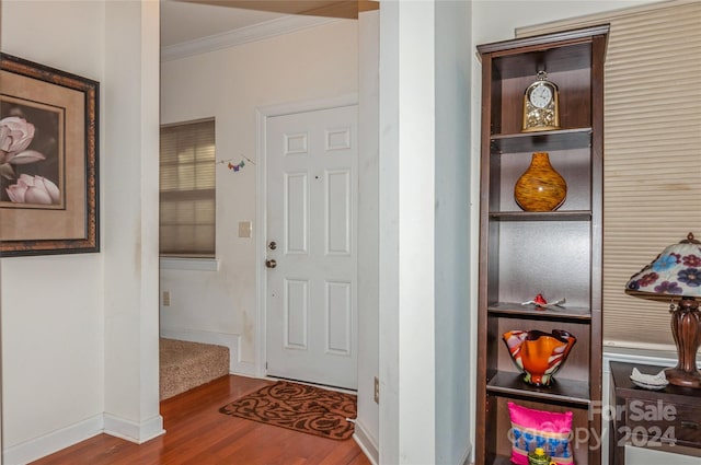 foyer entrance with crown molding and wood-type flooring