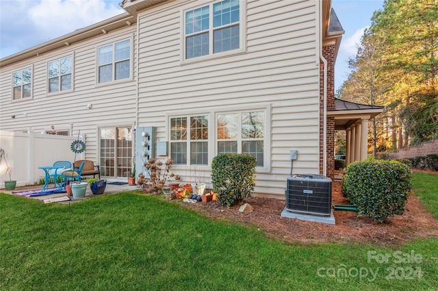 rear view of house featuring a yard, a patio, and central AC