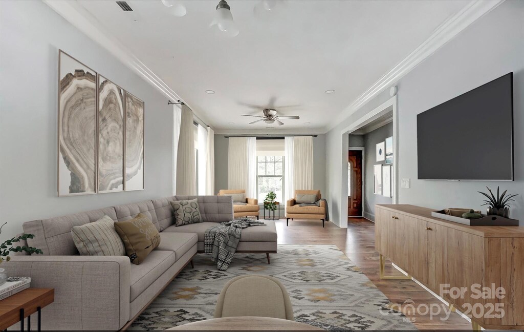 living room featuring wood-type flooring, ceiling fan, and crown molding