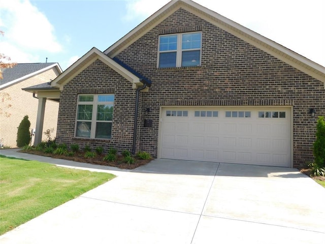 traditional-style home with a garage, driveway, and brick siding