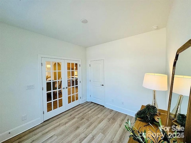 spare room with french doors, wood finished floors, and baseboards