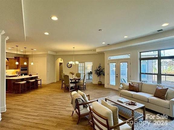 living area featuring recessed lighting, french doors, a healthy amount of sunlight, and wood finished floors