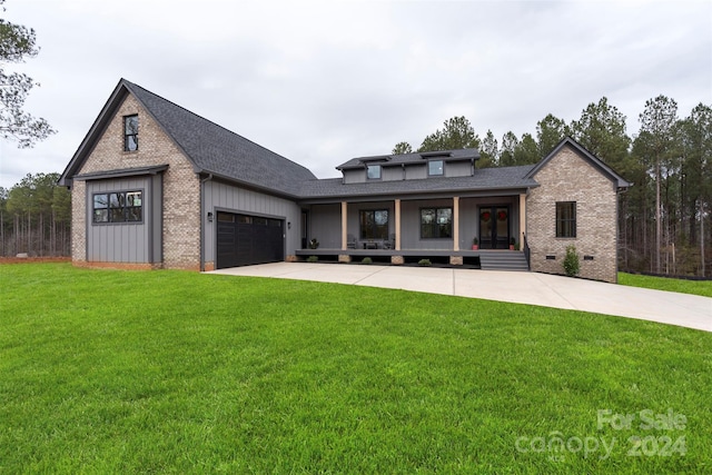 view of front of property featuring a front yard, a porch, and a garage