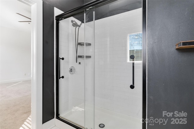 bathroom with ceiling fan and a shower with shower door