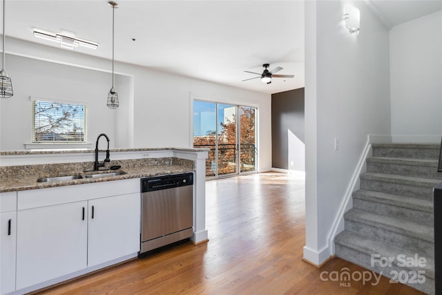 kitchen with white cabinets, sink, hanging light fixtures, stainless steel dishwasher, and ceiling fan