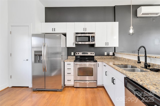 kitchen featuring appliances with stainless steel finishes, white cabinetry, pendant lighting, and sink