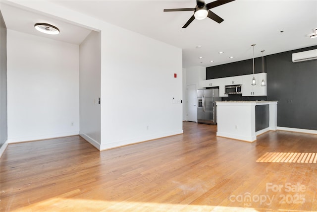 unfurnished living room with hardwood / wood-style floors, an AC wall unit, and ceiling fan