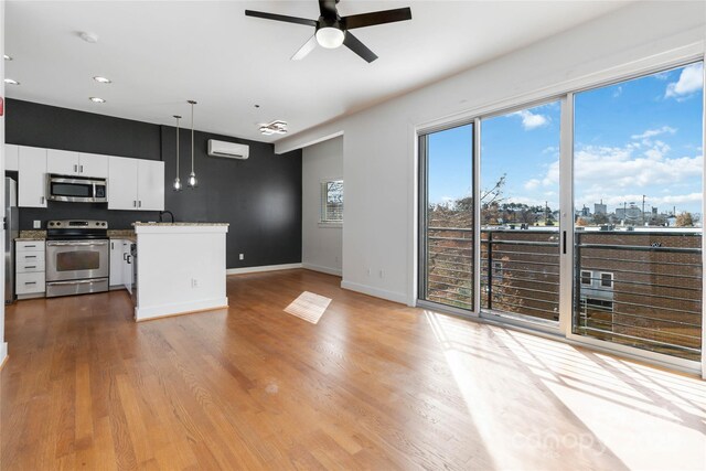 kitchen with a wealth of natural light, white cabinetry, pendant lighting, and appliances with stainless steel finishes