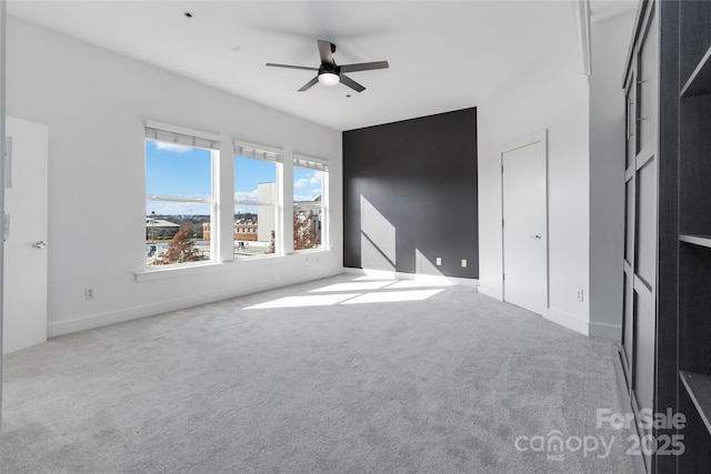 carpeted spare room featuring ceiling fan