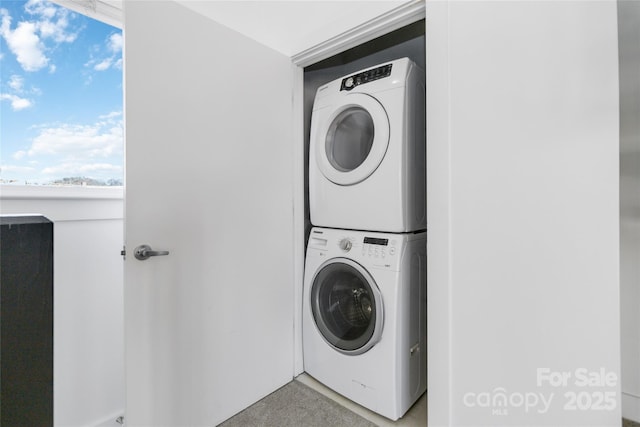 washroom featuring stacked washer / drying machine