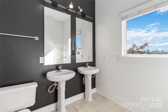 bathroom with tile patterned floors, double sink, and toilet