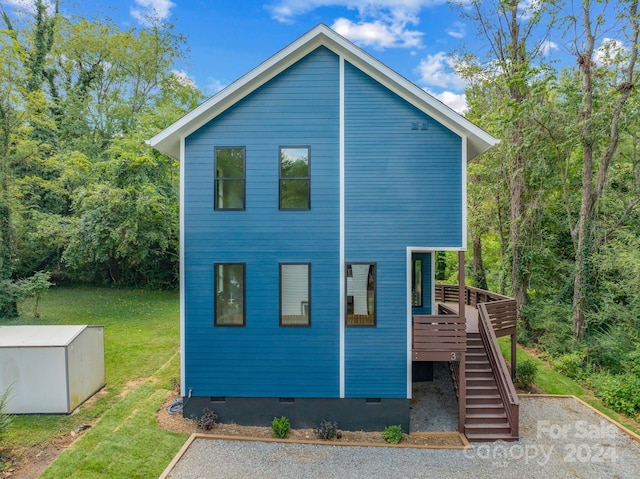 view of home's exterior featuring a wooden deck and a lawn