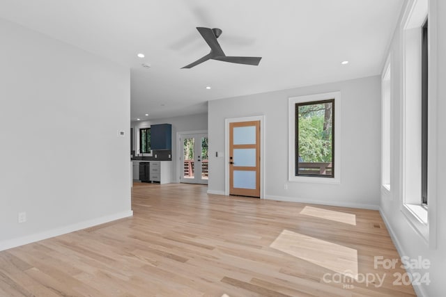 unfurnished living room featuring ceiling fan, french doors, and light hardwood / wood-style floors