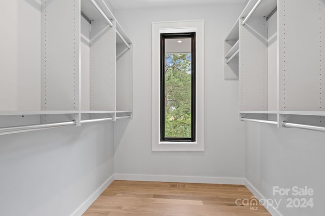 walk in closet with hardwood / wood-style floors