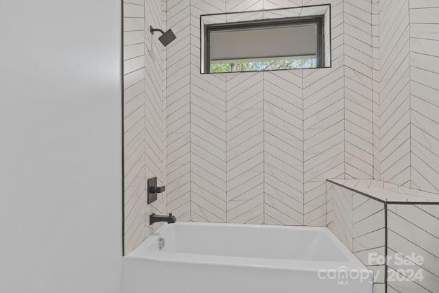 bathroom featuring tiled shower / bath