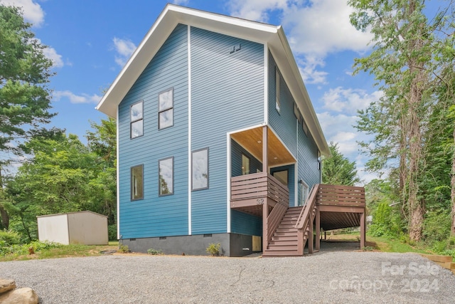 view of home's exterior featuring a deck and a storage unit