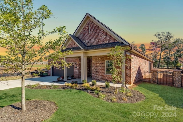 view of front of home featuring a lawn, a garage, and covered porch