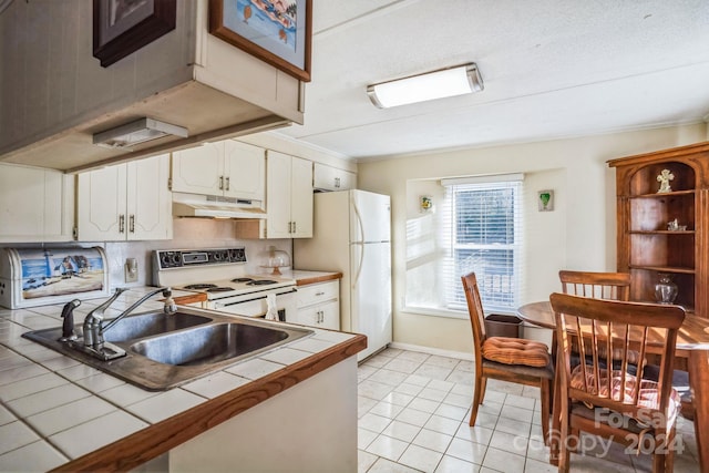 kitchen featuring white cabinetry, tile counters, sink, white appliances, and light tile patterned flooring