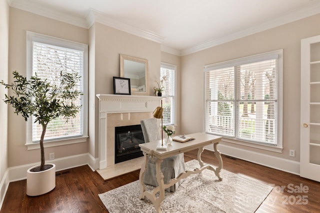 office space featuring dark wood-type flooring, ornamental molding, and a premium fireplace