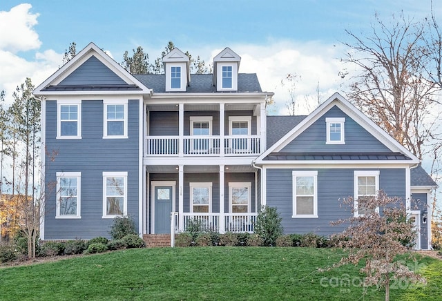 view of front of house featuring covered porch, a balcony, and a front lawn