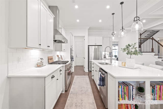 kitchen featuring high end appliances, sink, pendant lighting, a center island with sink, and white cabinetry