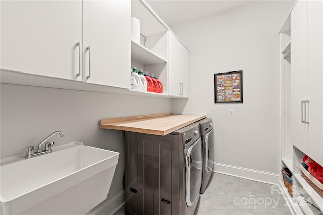 laundry area with washing machine and dryer, sink, and cabinets