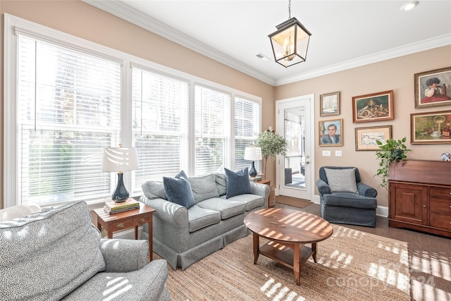 living room with hardwood / wood-style flooring, crown molding, and a notable chandelier