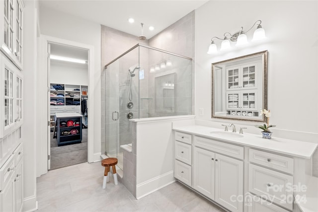 bathroom with tile patterned flooring, vanity, and walk in shower