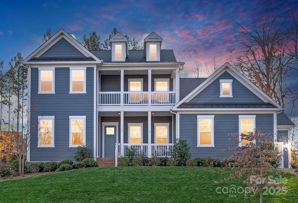 128 Shimmer Lake Ln, Belmont, NC 28012 - view of front facade with a front lawn, a balcony, a standing seam roof, covered porch, and metal roof
