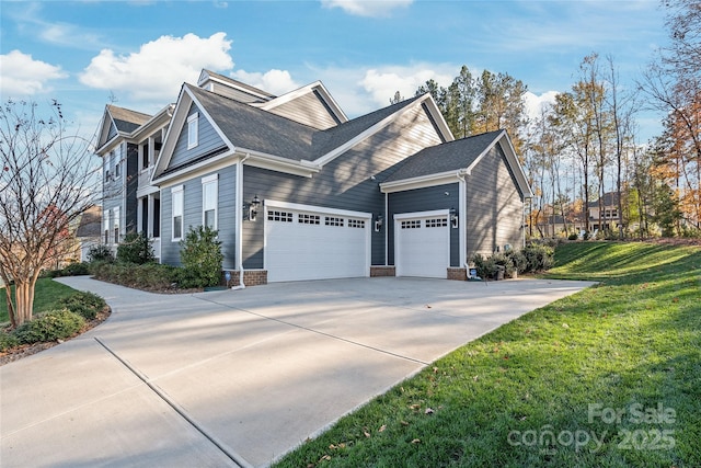 view of side of property with a yard, an attached garage, and driveway