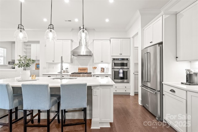 kitchen with light countertops, backsplash, a sink, crown molding, and appliances with stainless steel finishes