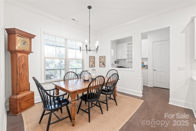 dining area with wood finished floors, visible vents, ornamental molding, and a notable chandelier