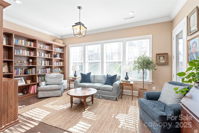 sitting room with baseboards, ornamental molding, wood finished floors, and visible vents