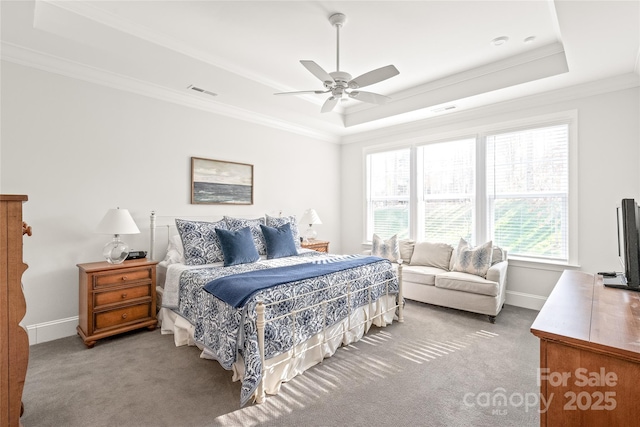 bedroom with a tray ceiling, carpet flooring, baseboards, visible vents, and ornamental molding
