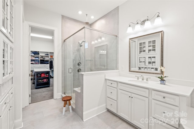 full bath featuring a stall shower, a spacious closet, recessed lighting, tile patterned flooring, and vanity