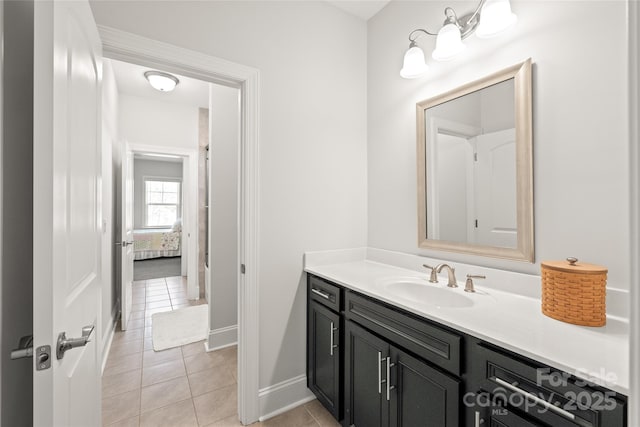bathroom with baseboards, vanity, tile patterned floors, and ensuite bathroom
