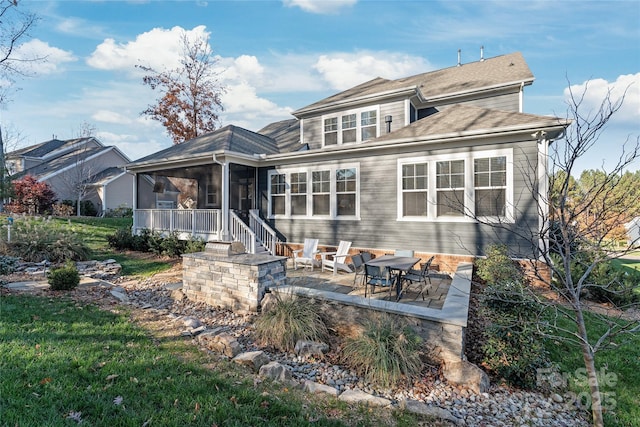rear view of property featuring a sunroom and a patio