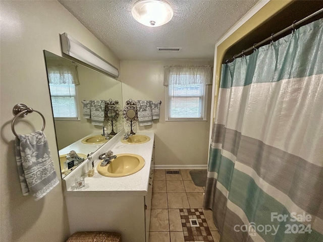 bathroom with tile patterned flooring, vanity, a textured ceiling, and a shower with shower curtain