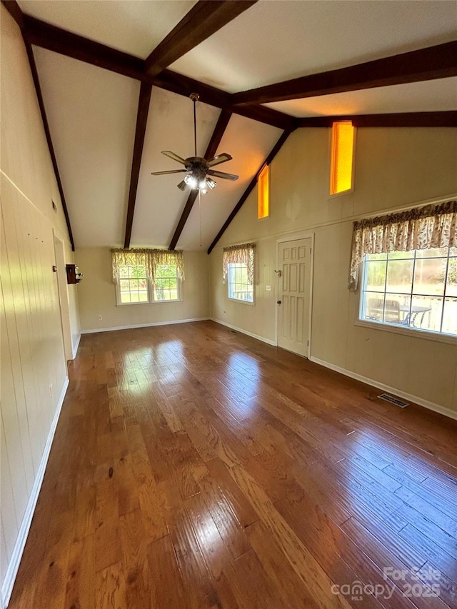 unfurnished living room featuring beamed ceiling, hardwood / wood-style flooring, visible vents, and a ceiling fan