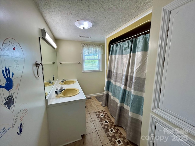 full bath with tile patterned flooring, visible vents, a sink, and a textured ceiling