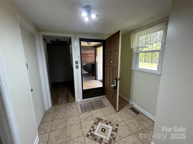 interior space with baseboards, visible vents, and light tile patterned floors